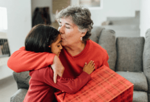 top 7 personalized gifts for grandparents grandma holding gift and kissing granddaughter on the forehead